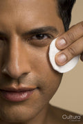 Close-up of man cleaning face with cotton pad