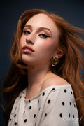 Woman in a polka dot top with windswept hair in a studio