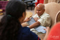 Nursing assistant adjusting blood pressure gauge on senior mans arm in nursing home
