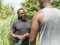 Two men drinking water after exercising outdoors