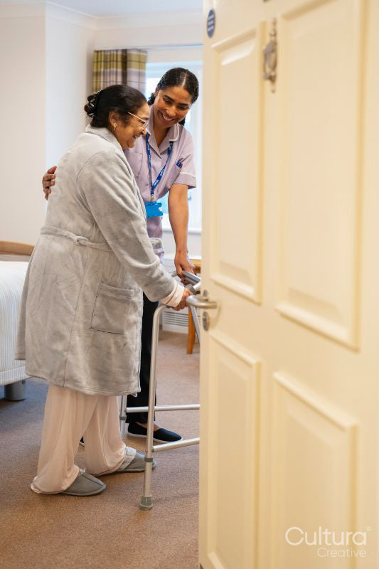 Nurse helping senior lady in her room at nursing home