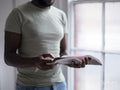 Midsection of person holding open book by window