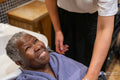 Smiling senior woman getting ready for hair wash in hair salon