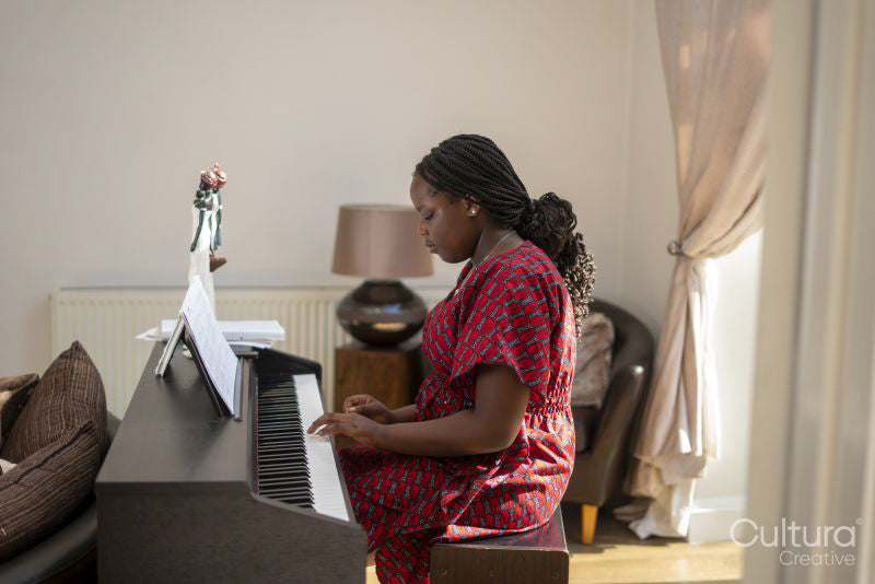 Teenage girl playing piano at home