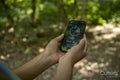 Young woman using compass on smart phone, close up of hands