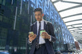 Businessman walking in business district and using phone