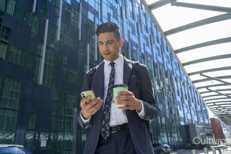 Businessman walking in business district and using phone
