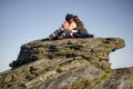 Two senior women sitting on rock formation
