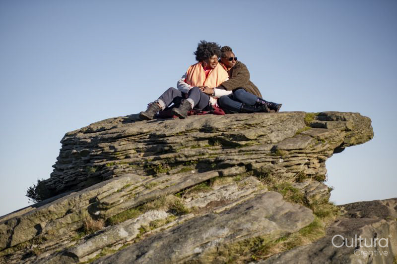 Two senior women sitting on rock formation