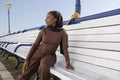 Smiling Muslim woman sitting on bench on sunny day