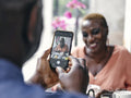 Close-up of man photographing woman at hotel table