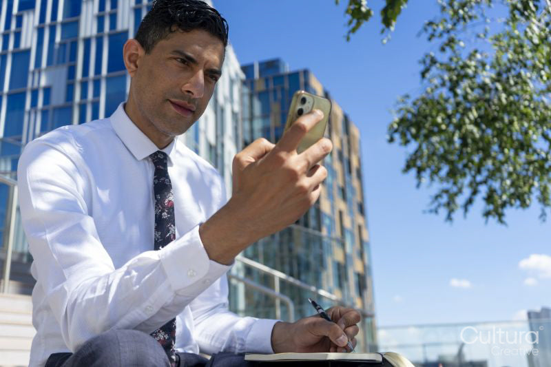 Businessman having using phone outdoors