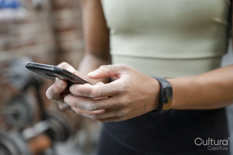 Woman using smart phone on gym
