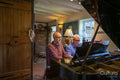 Senior male couple playing piano at home