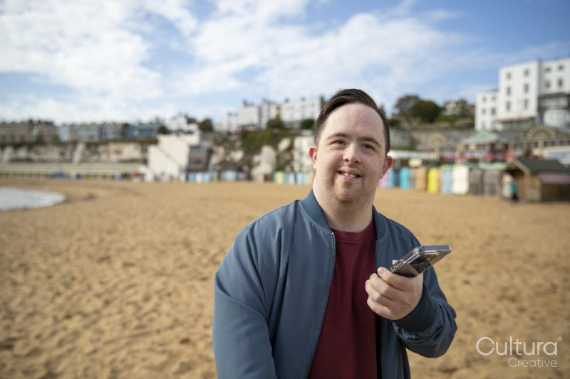 Portrait of mid adult man on beach holding phone