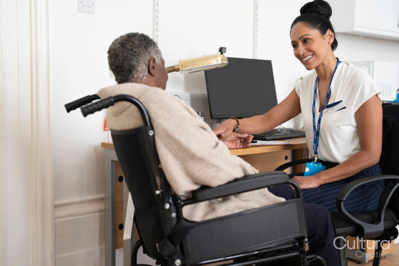 Smiling female doctor talking to senior woman sitting in wheelchair
