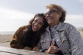 Mother and daughter resting by picnic table on beach
