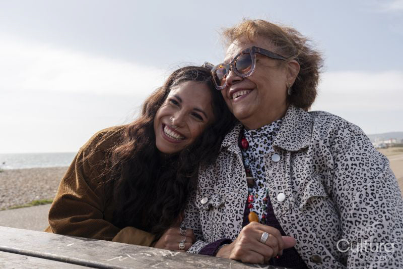Mother and daughter resting by picnic table on beach