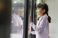 Little girl looking out window