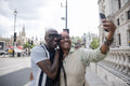Happy mature couple taking selfie while visiting city