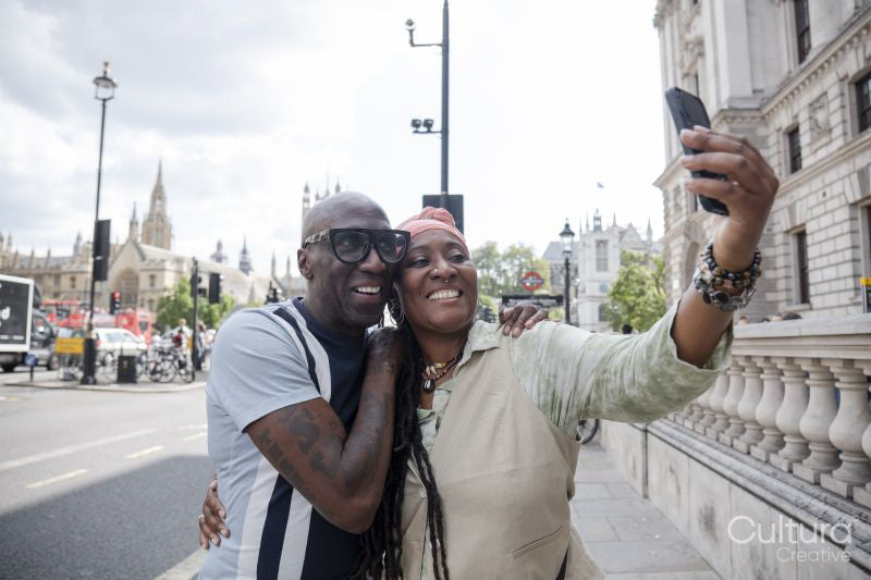 Happy mature couple taking selfie while visiting city