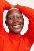 Smiling woman with short white hair, arms raised