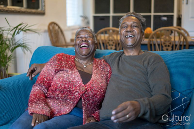 Senior couple sitting on sofa and laughing