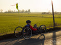 Disabled man riding handcycle on country road at sunset