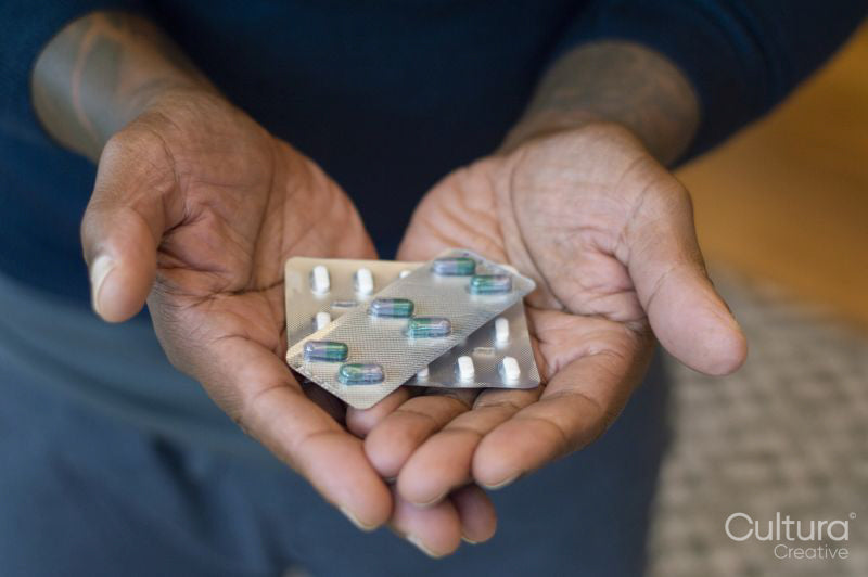 Man holding medications, close up