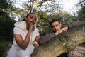 Portrait of couple leaning on tree branch