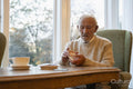 Senior man sitting at table and shuffling cards