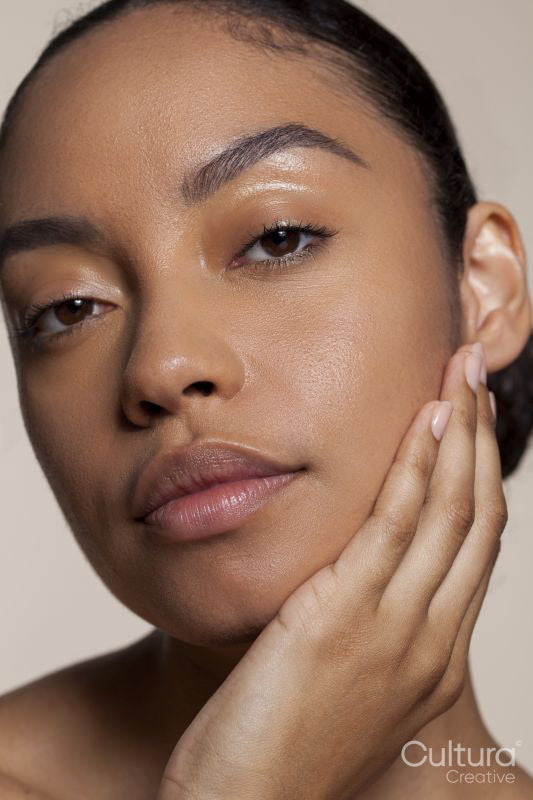 Portrait of young woman touching face