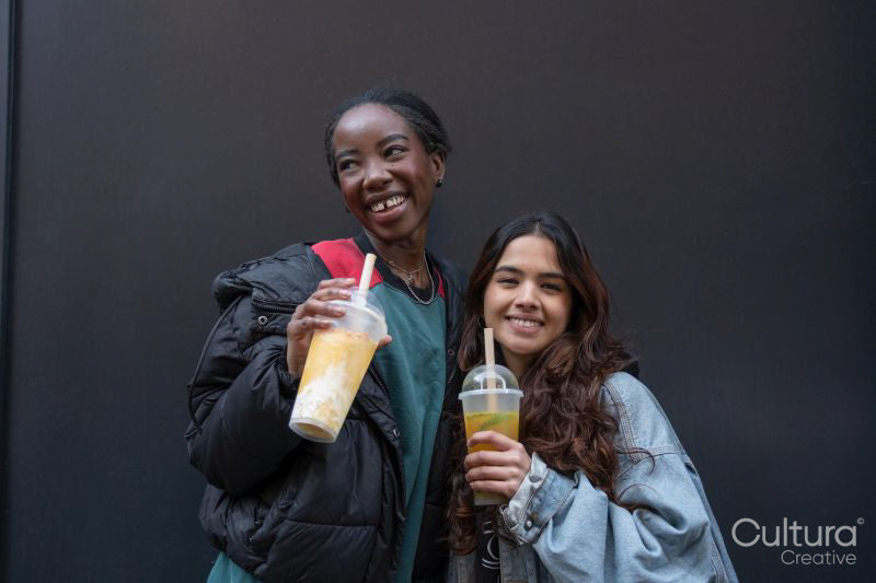 Portrait of two cheerful women drinking bubble tea
