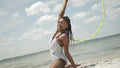 Teenage girl with hula hoop on beach