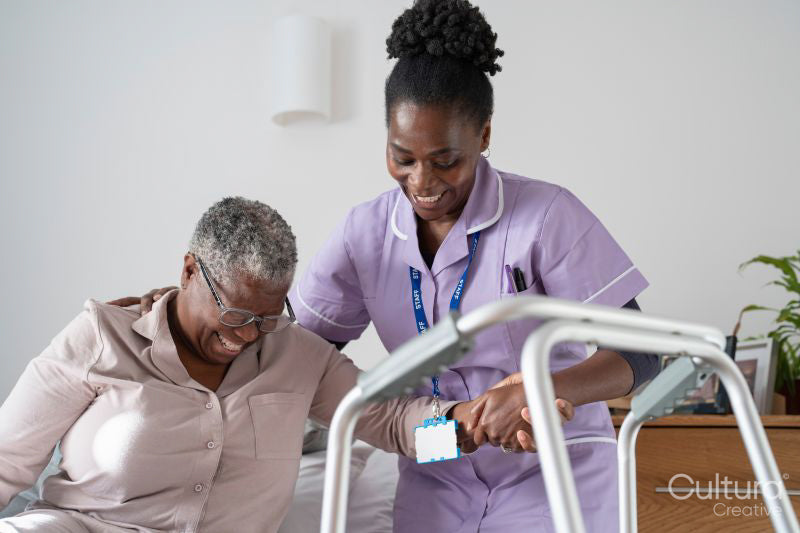 Caregiver assisting smiling senior woman sitting on bed