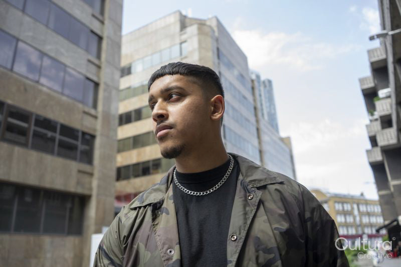 Young man wearing camouflage jacket,black tshirt and necklace