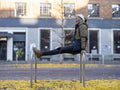 Man leaning on bicycle stand in city
