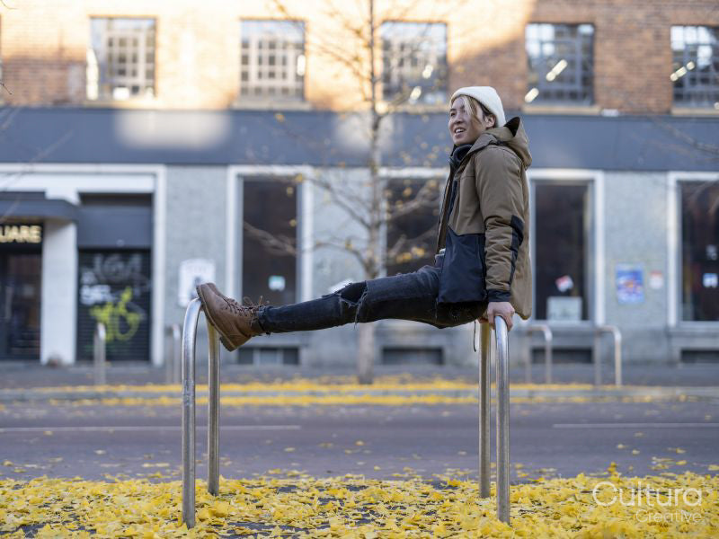 Man leaning on bicycle stand in city