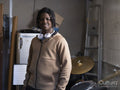 Portrait of teenage boy standing next to drums