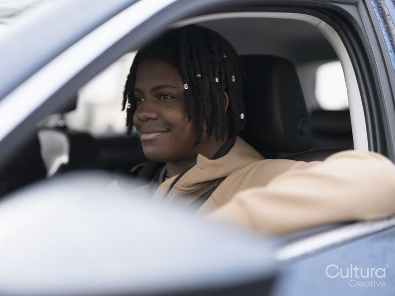 Smiling teenage boy sitting in car