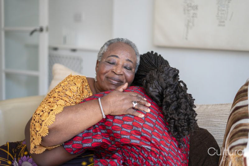 Smiling senior woman hugging teenage granddaughter at home