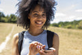 Young woman hiking in countryside and using smart phone