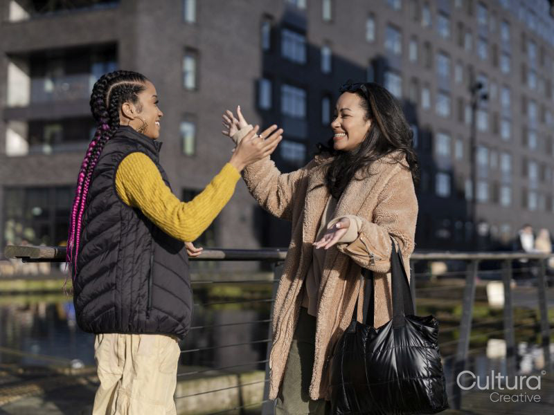 Two young women meeting in street