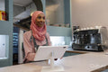 Young woman in hijab working in cafe