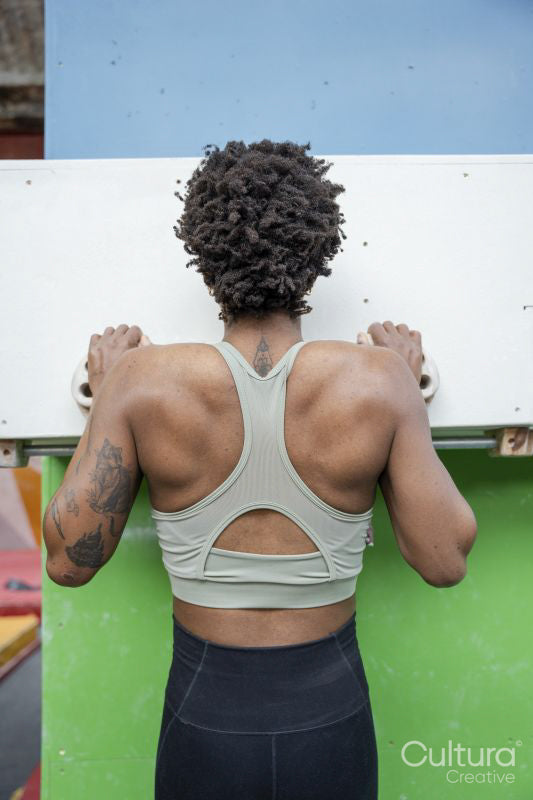 Rear view of woman exercising on climbing wall