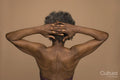 Rear view of shirtless senior woman with hands behind head