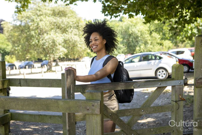 Young woman with backpack hiking in countryside