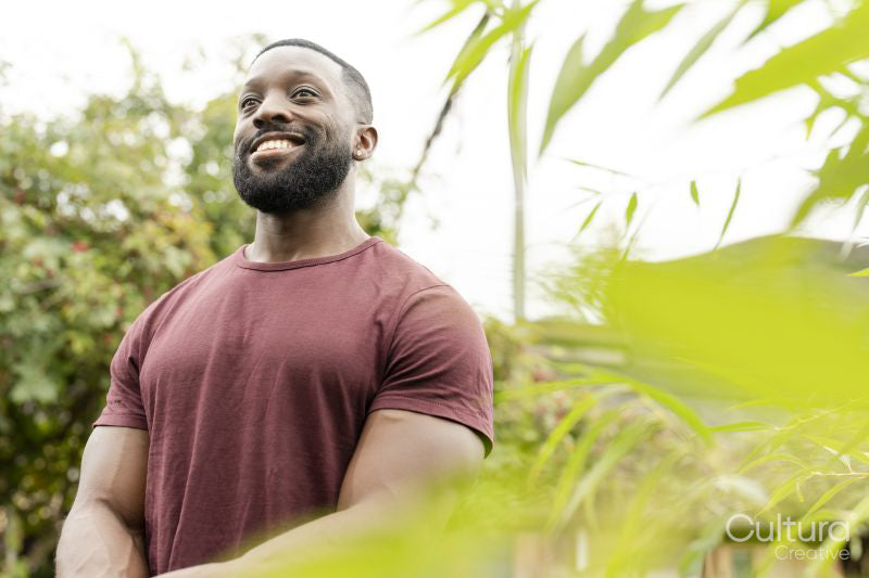 Portrait of smiling man standing in urban vegetable garden