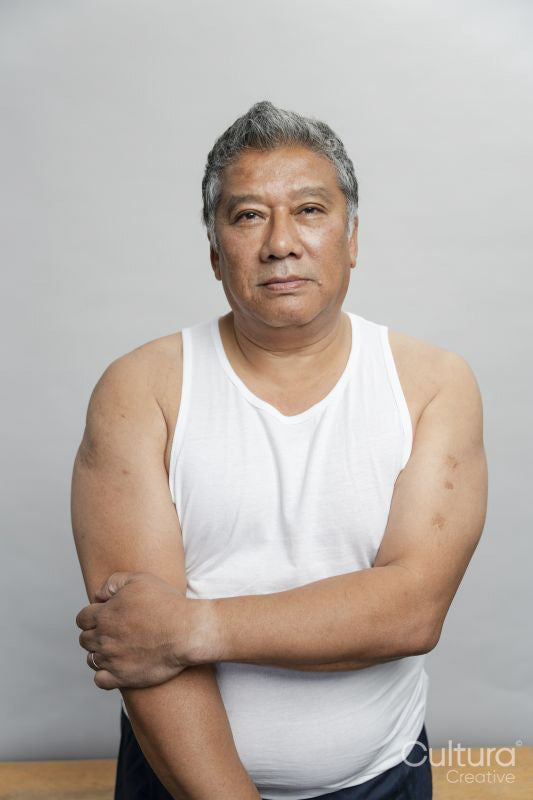 Portrait of serious senior man against gray background