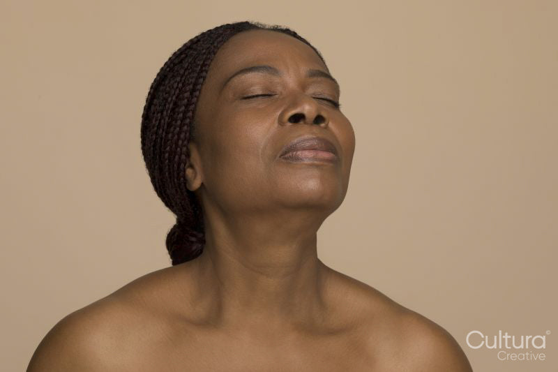 Studio shot of mature woman with braided hair and eyes closed